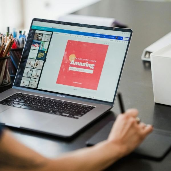 Web designer working on website interface design using laptop and drawing tablet